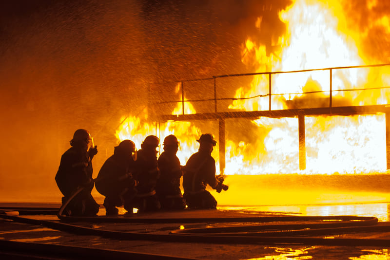 fire-fighting-course-firefighters-spraying-down-burning-structure-during-firefighting-exercise