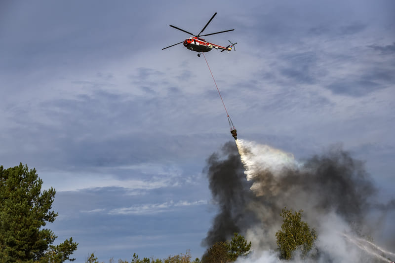 fire-fighting-course-helicopter-dropping-a-load-of-water-to-extinguish-the-fire-in-the-forest