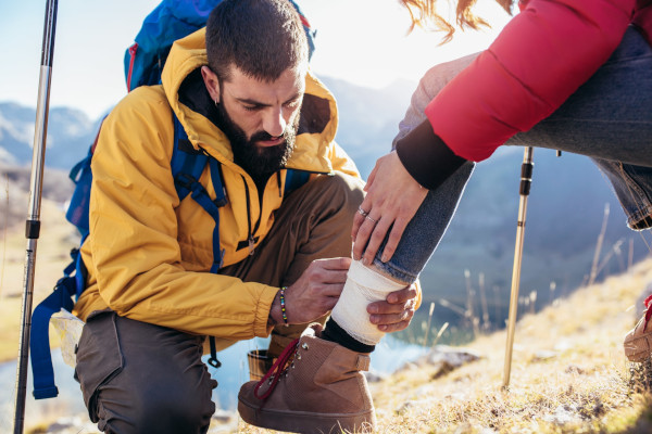 First-aid-course-a-woman-has-sprained-her-ankle-while-hiking-her-friend-uses-the-first-aid-kit-138371910