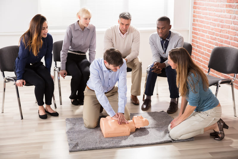 First-Aid-Course-instructor-showing-cpr-training-on-dummy