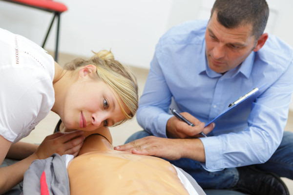 first-aid-training-woman-listening-for-breath-during-first-aid-training-course