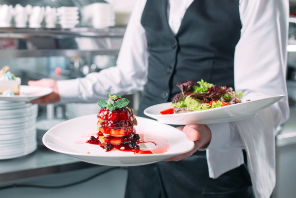 health-and-safety-course-waiter-serving-in-motion-on-duty-in-restaurant-the-waiter-carries-dishes-154983025