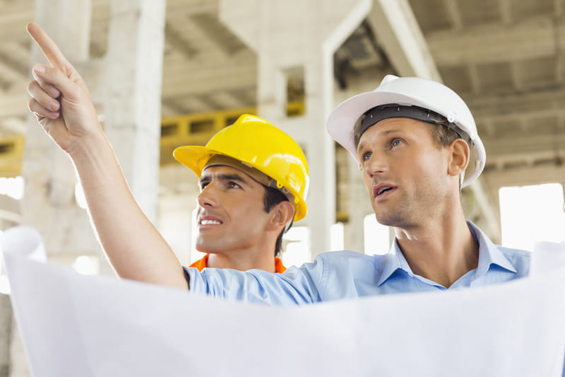 safety-officer-course-architect-explaining-building-plan-to-colleague-at-construction-site