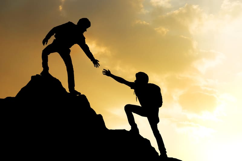 safety-officer-course-people-helping-on-peak-mountain-and-sunrise-background-climbing