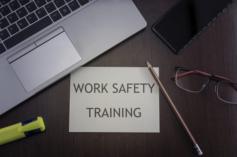 safety-officer-course-work-place-safety-training-card-top-view-of-office-table-desktop-background-with-laptop-phone-glasses-and-pencil-with-card-with