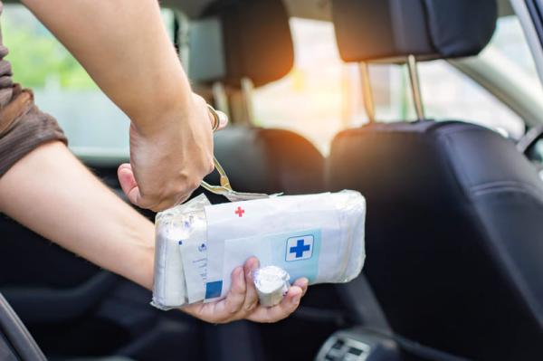 33-0.first-aid-course-a-man-opens-a-bandage-in-a-car-first-aid-kit-with-scissors-accident-first-aid-concept.0f3bdebdefe9ebf474b5c39afce0e772