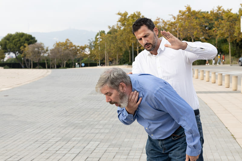 first-aid-training-shot-of-a-young-male-trying-to-perform-choking-first-aid-to-a-middle-aged-male-by-giving-back-blows