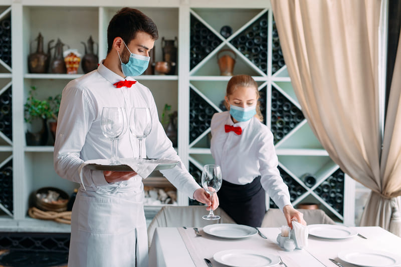 first-aid-training-waiter-in-a-medical-protective-mask-serves-a-table-in-the-restaurant-employees-of-a-restaurant-or-hotel-in-protective