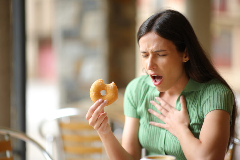 first-aid-training-woman-choking-eating-doughnut-in-a-bar