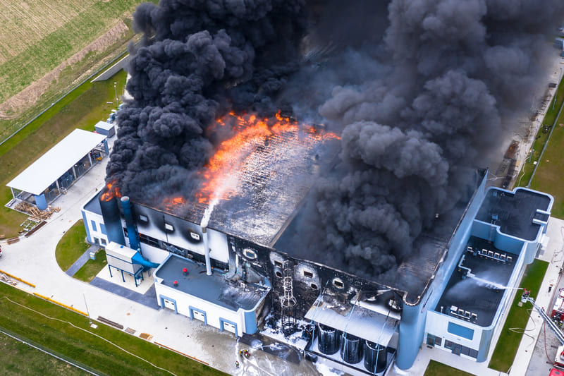 fire-fighting-course-aerial-view-of-burnt-industrial-warehouse-or-logistics-center-building-after-big-fire-with-huge-smoke-from-burned-roof